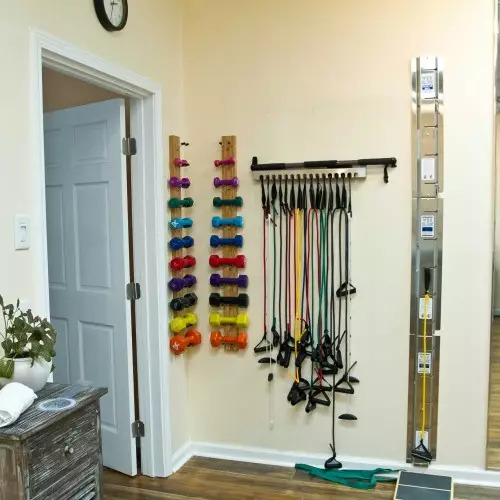 A room with a variety of exercise equipment hanging on the wall.